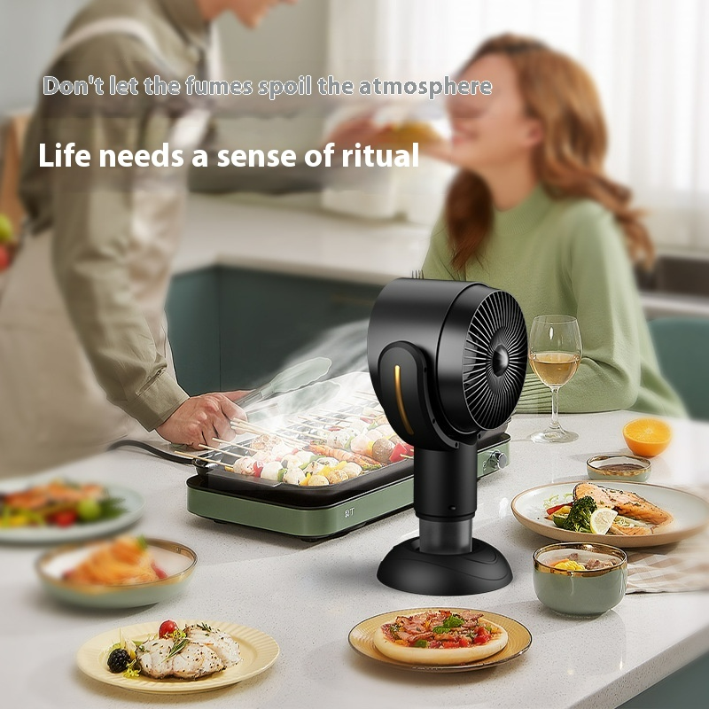 Black countertop smoke extractor beside a tabletop grill and plated meal