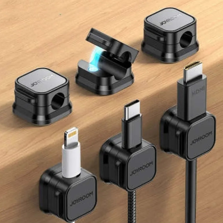 Black magnetic cable keepers organizing charging cords on a desk